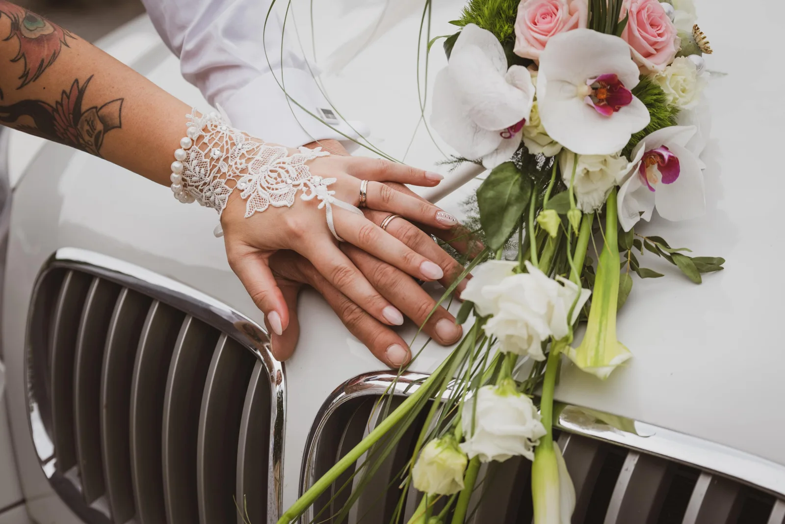 Bouquet et mains des mariés sur une voiture — Eric Bomal